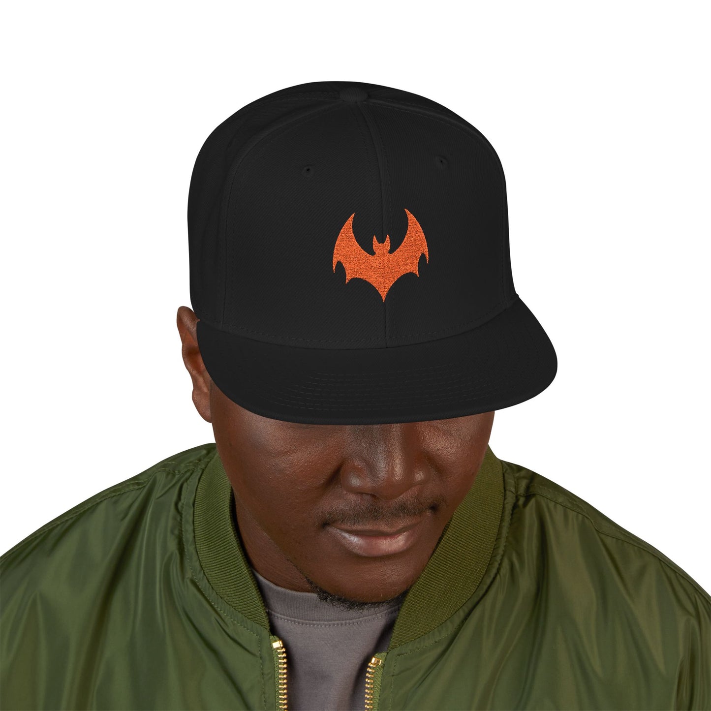 Person wearing a black cap with an orange logo on a white background