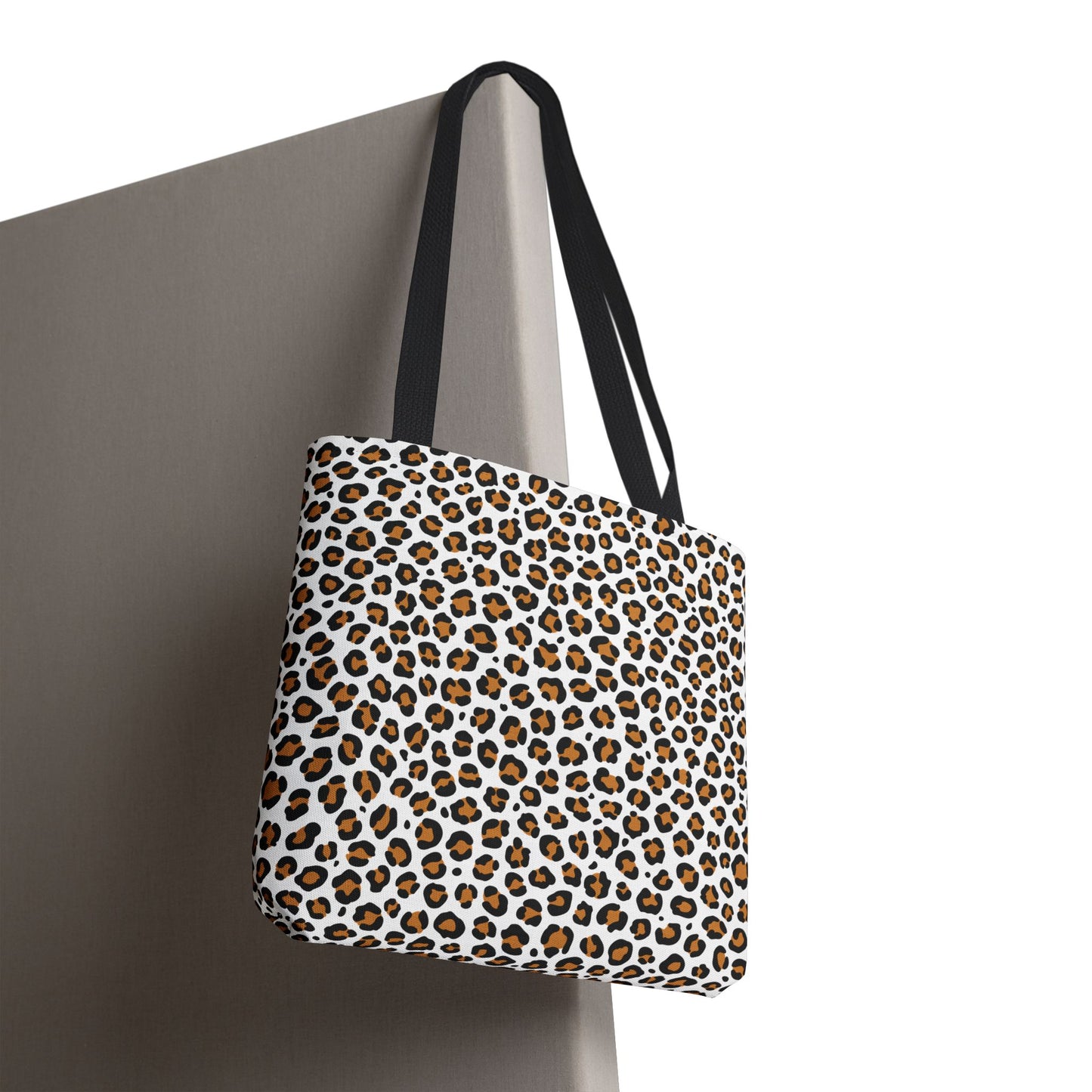Leopard print tote bag with black straps on a neutral background