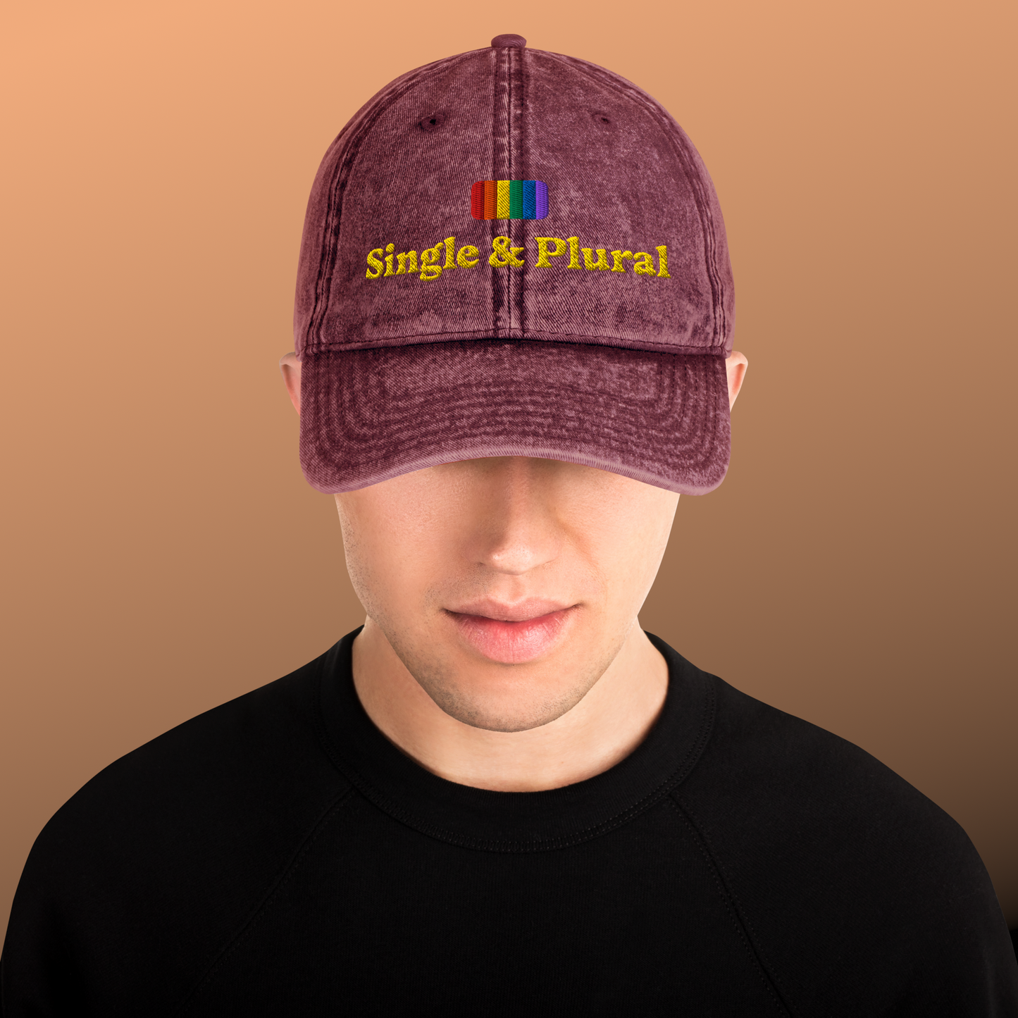 Purple cap with 'Single & Plural' text and rainbow colors on a brown background
