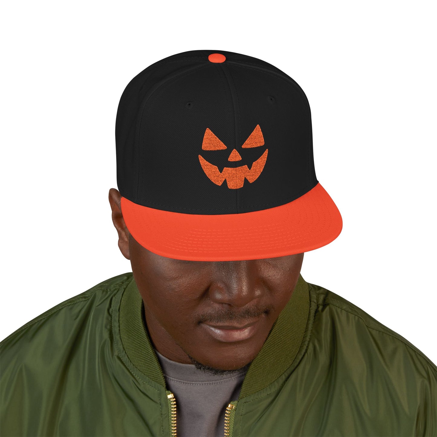 Person wearing a black and orange cap with a jack-o'-lantern design on a white background