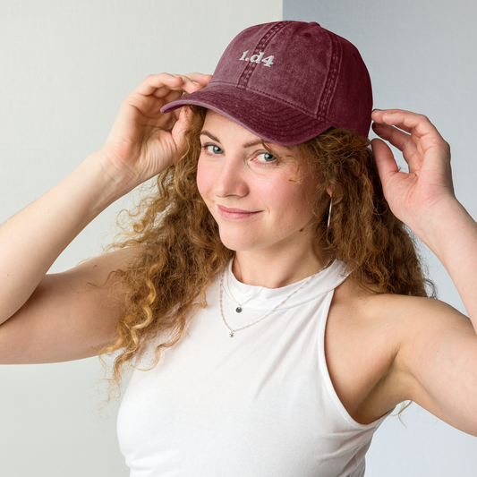 Woman wearing a maroon cap with 'LOL' on it against a plain background
