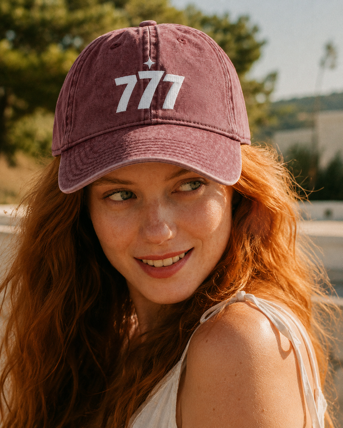 Woman wearing a maroon cap with '777' logo outdoors