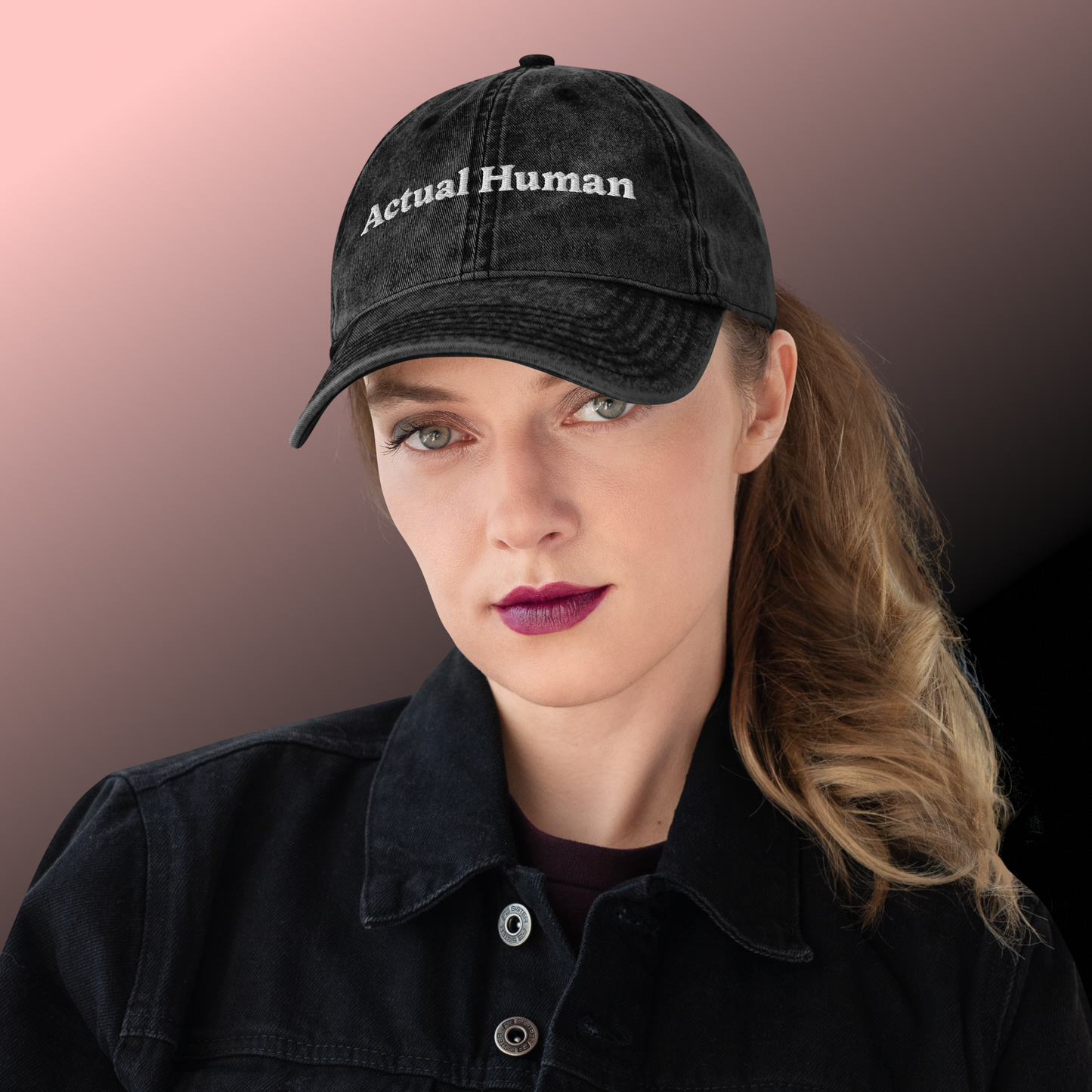 Person wearing a black cap with 'Actual Human' text against a gradient background