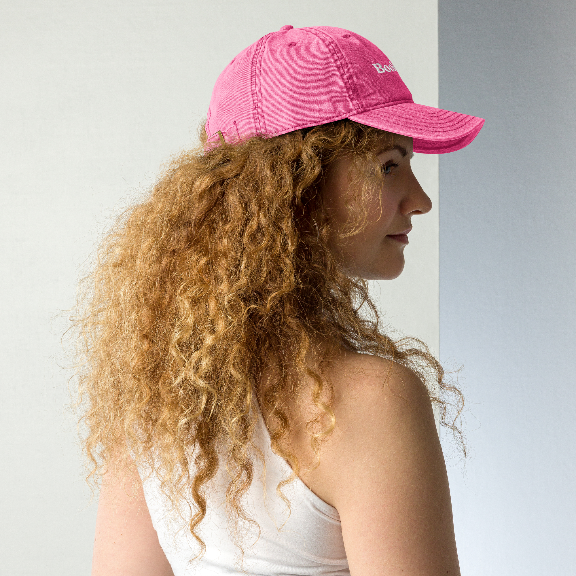 Woman wearing a pink cap with 'Bodhi' branding against a light background