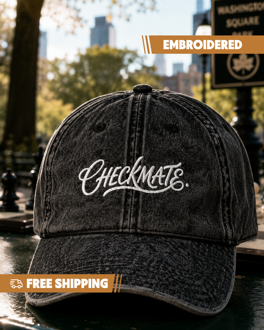 Black cap with 'CHECKMATE' embroidery in an urban park setting