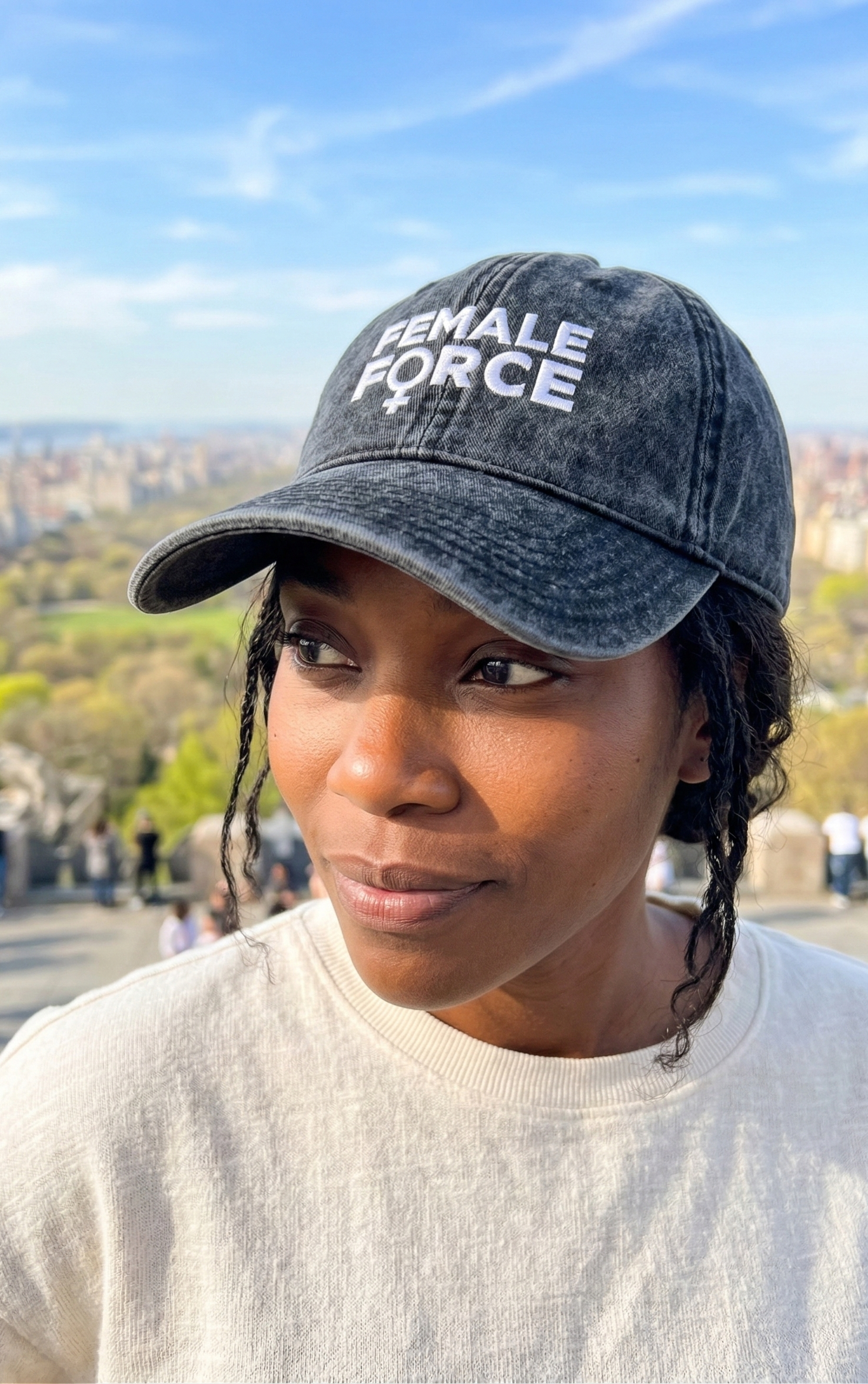 Person wearing a cap with 'FEMALE FORCE' text in an outdoor setting