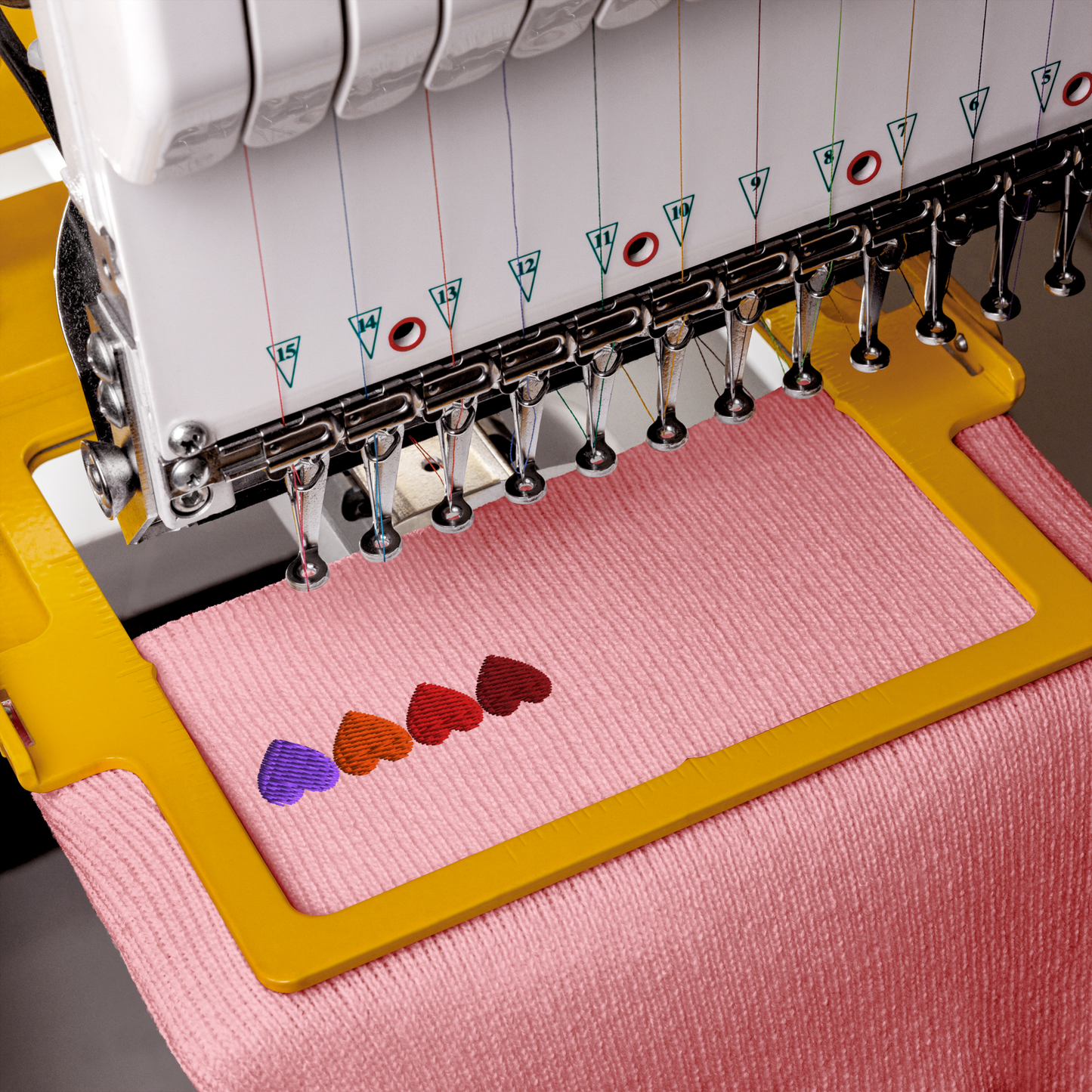 Embroidery machine with colorful embroidered hearts on pink fabric