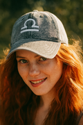 Woman wearing a cap with a libra zodiac symbol outdoors