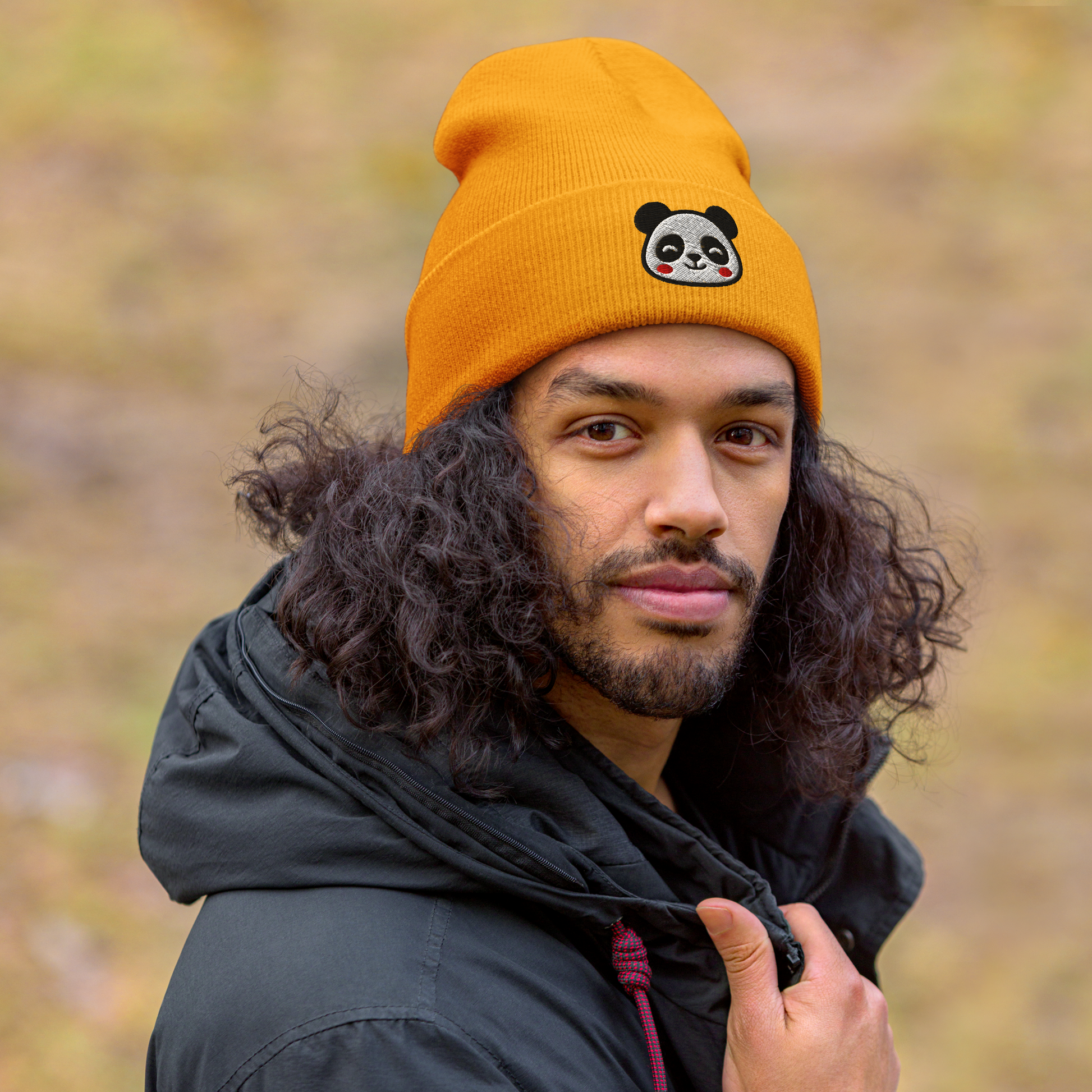 Person wearing an orange beanie with a panda design outdoors