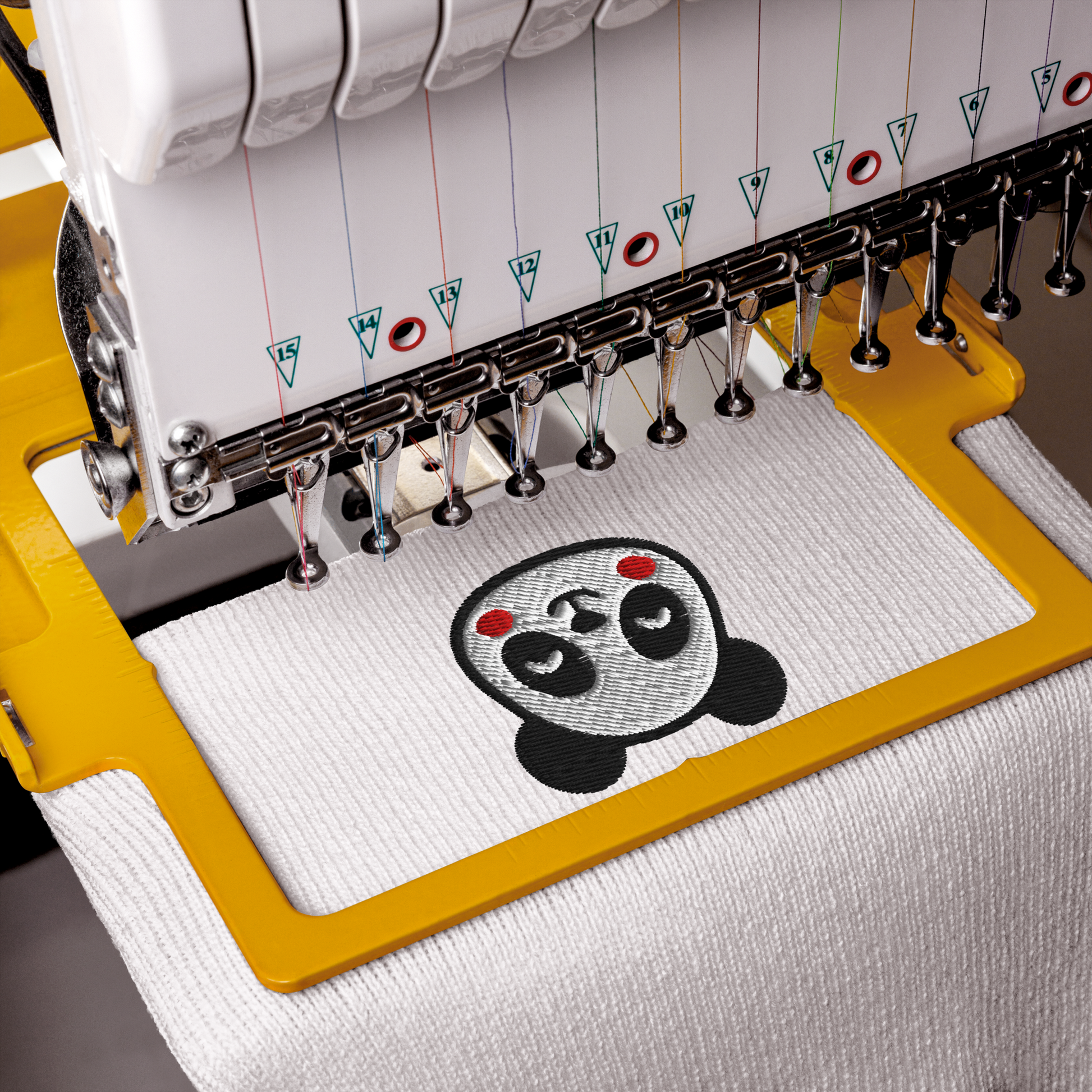 Embroidery machine with a panda design on a white fabric