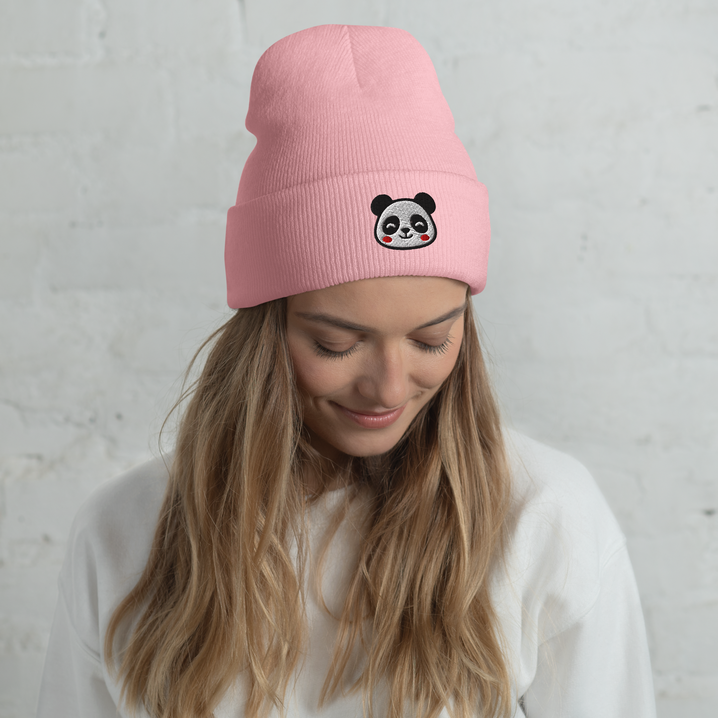 Person wearing a pink beanie with a panda design against a gray background