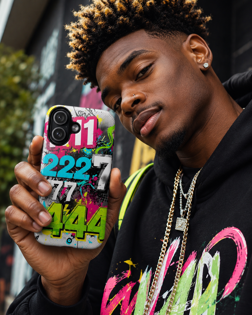 Man holding a phone with a colorful case featuring numbers and letters.