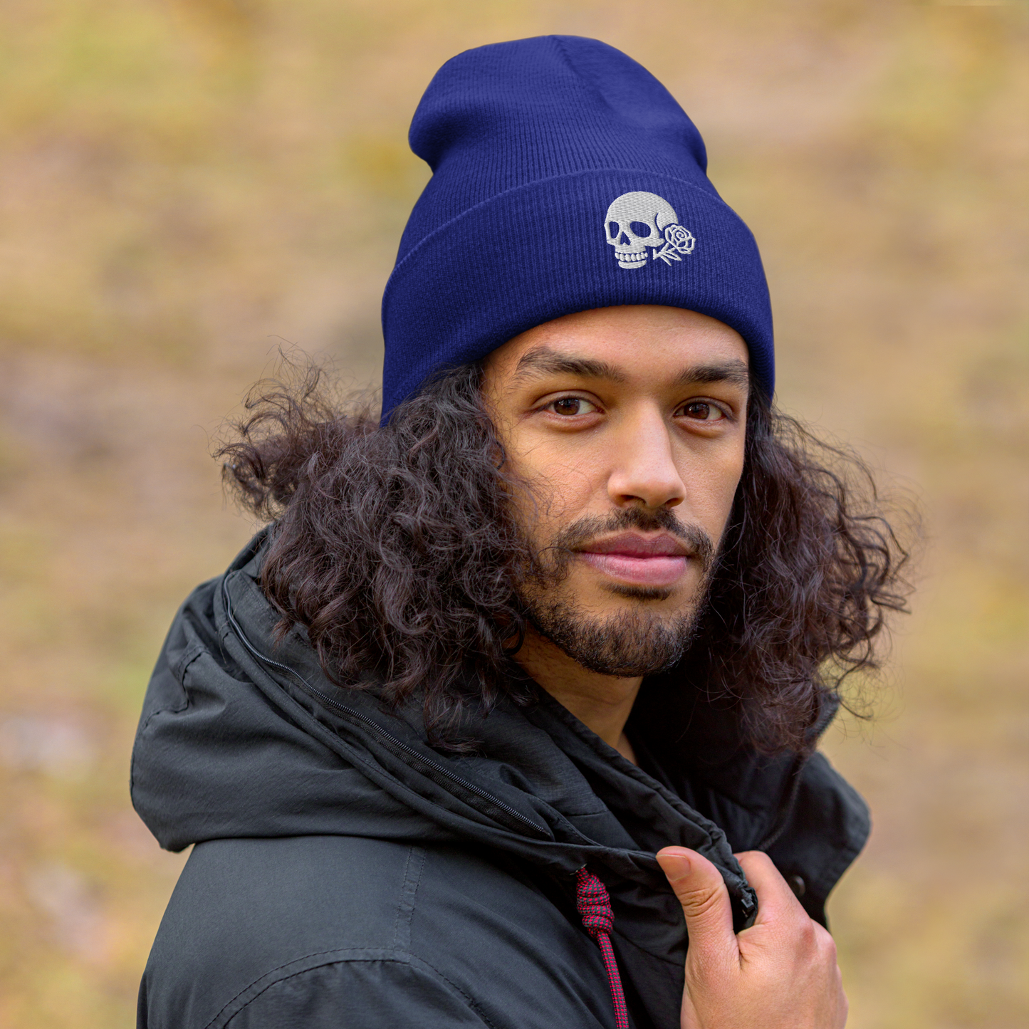 Person wearing a blue beanie with a skull design outdoors
