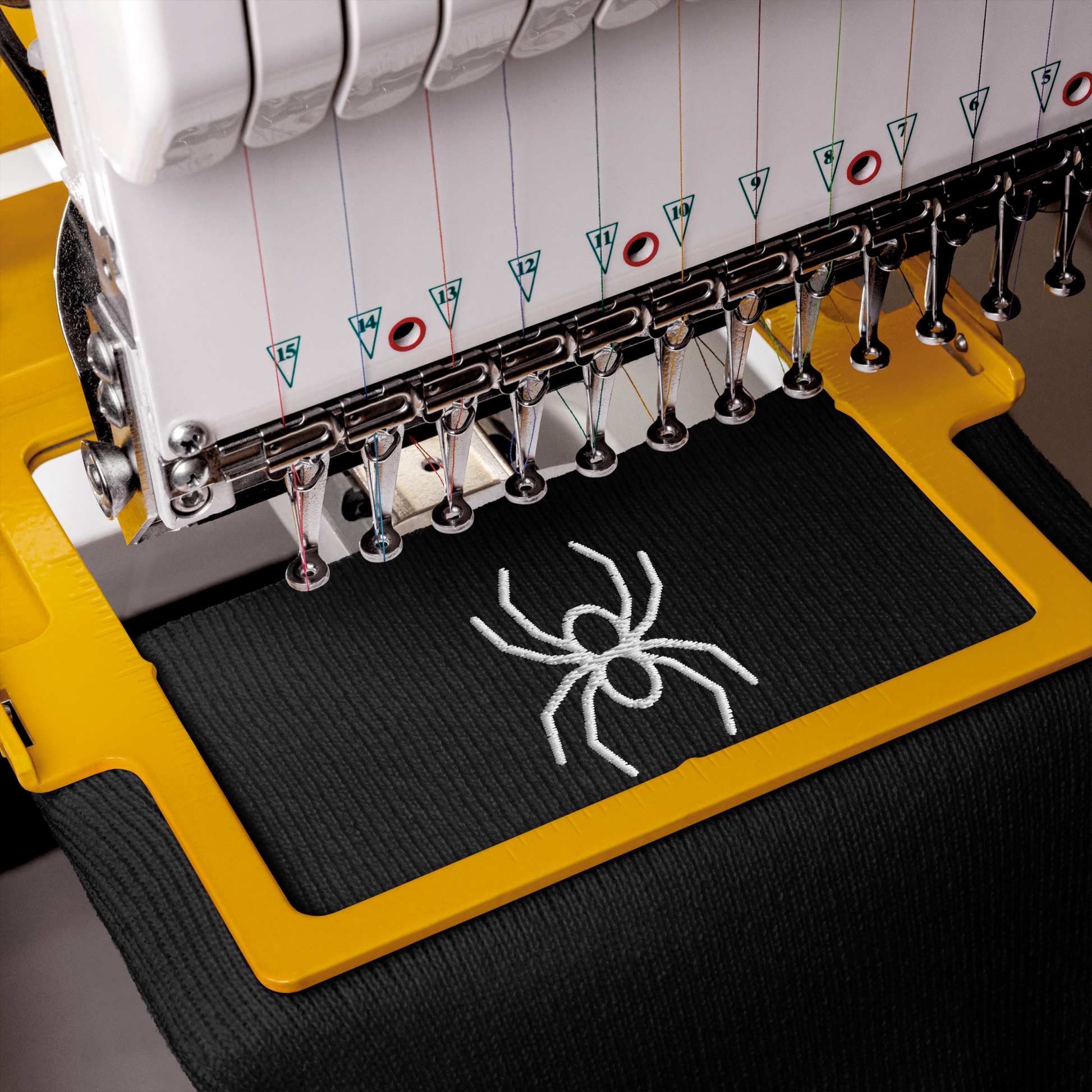 Embroidery machine with a spider design on a black fabric