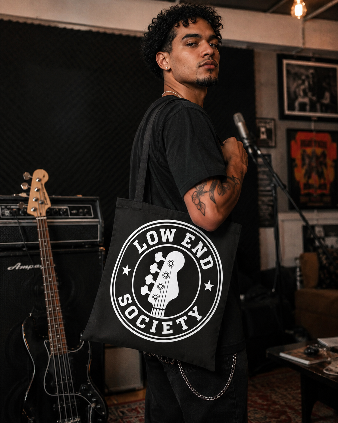 Person holding a black tote bag with 'Low End Society' logo in a music studio setting.