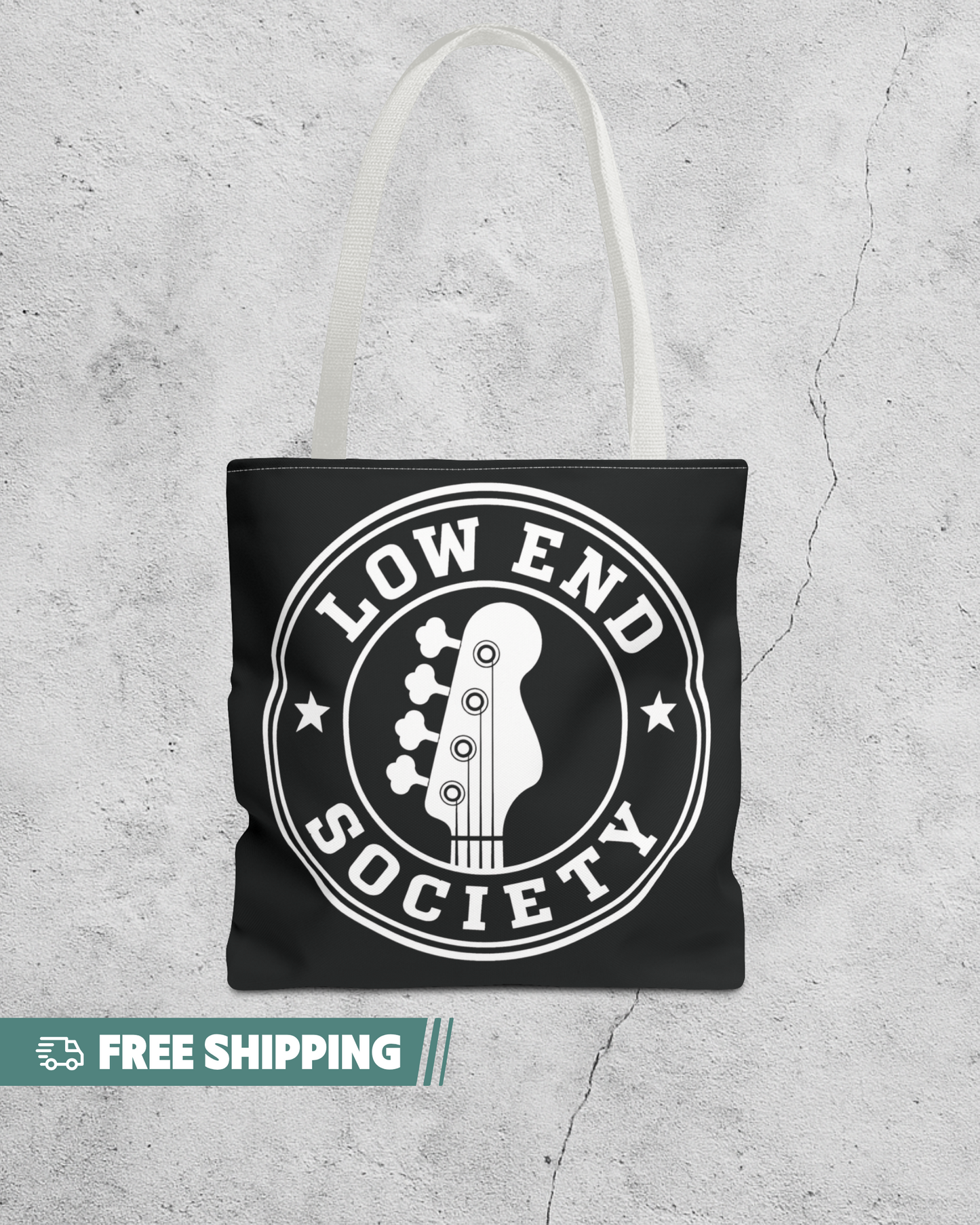 Black tote bag with 'Low End Society' design on a textured gray background
