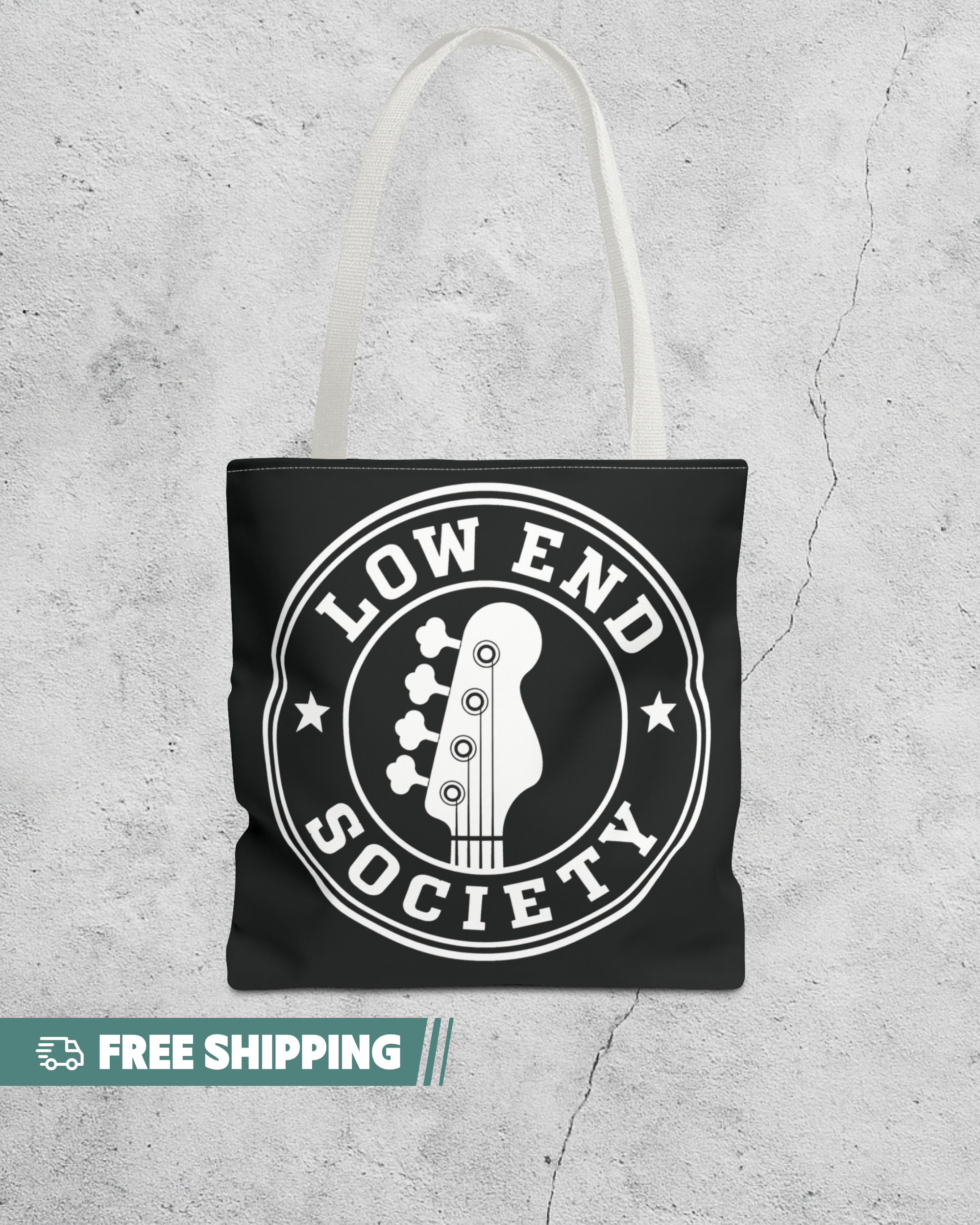 Black tote bag with 'Low End Society' design on a textured gray background