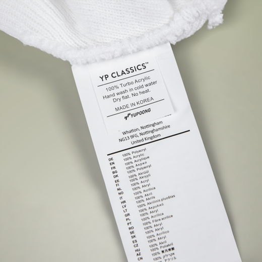 Label on a white towel with 'YP Classics' branding and care instructions.